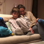videoblocks-mom-watching-tv-screen-with-her-kids-mother-watches-content-on-screen-with-_r0pdwya5l_thumbnail-full01