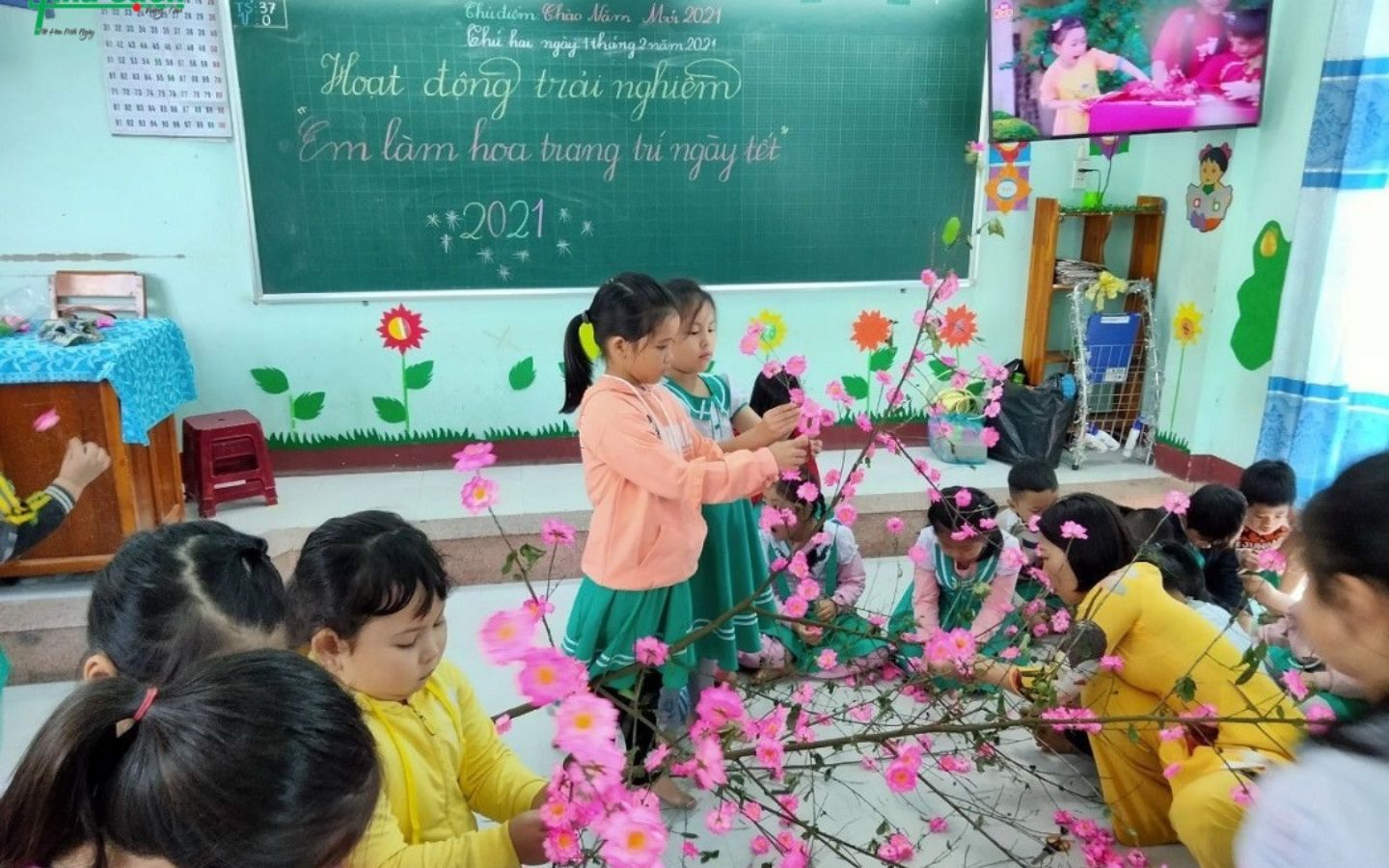 Các em học sinh cùng nhau làm cành đào trang trí
